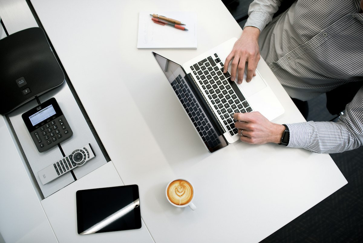 A person working on a laptop at a tidy office desk